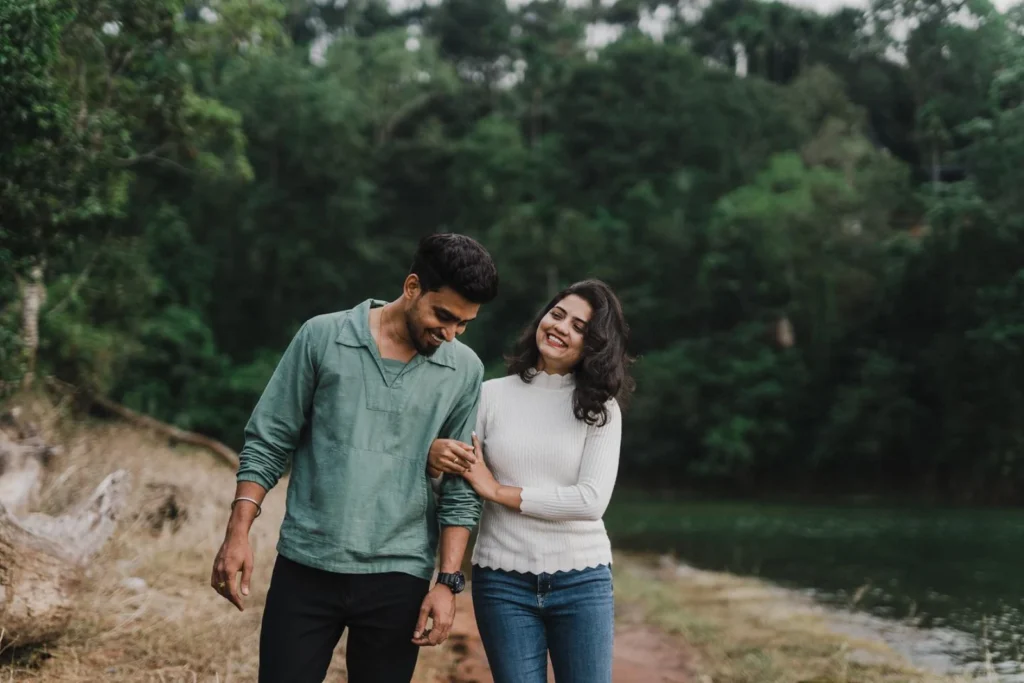 Bride holding groom's hand walking in natural outdoor setting during candid pre-wedding shoot