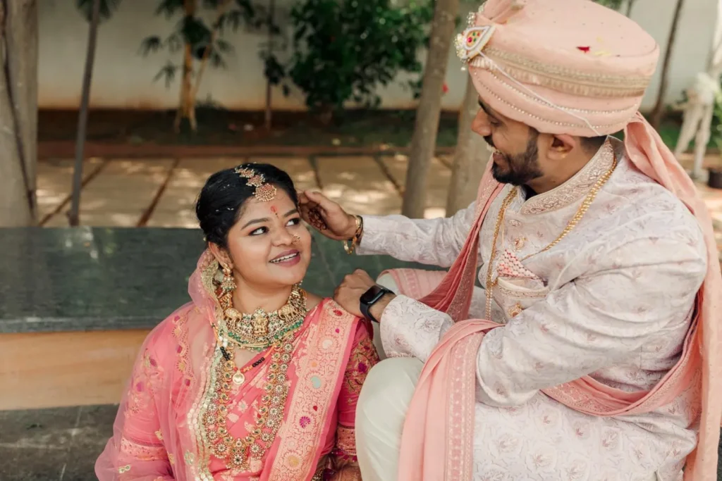 Manaswini & Ullas Jain candid moment after wedding with bride smiling and admiring groom as he gently holds her head,