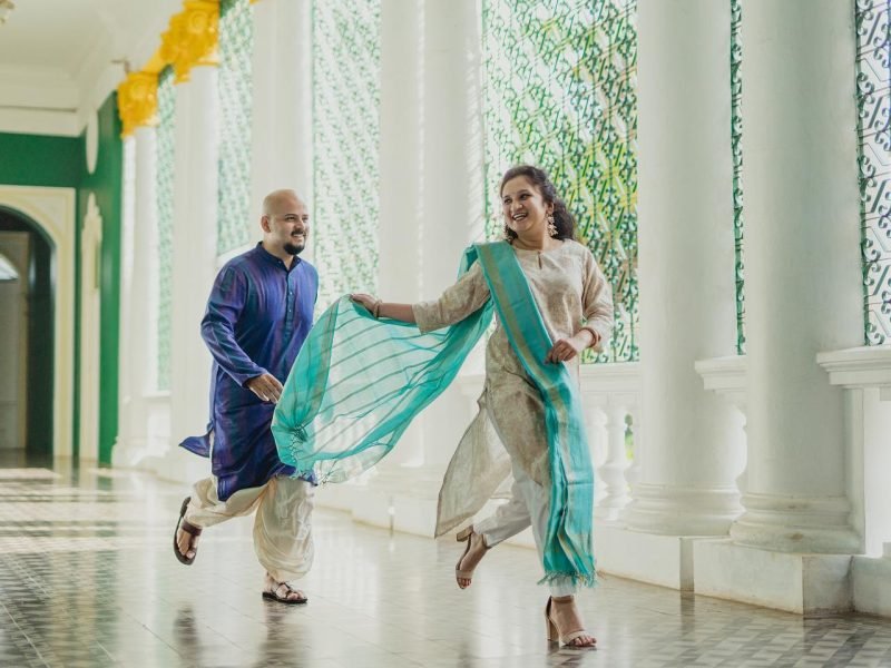 bride running as groom follows smiling to catch her capture in white palace