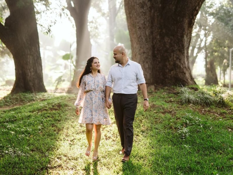 Bride and groom walking down greenery mountain area with yellow sunshine in background