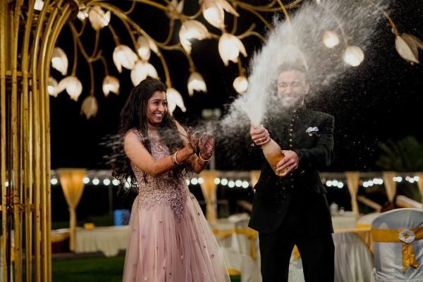 Bride and groom splashing cocktails during wedding night party captured by photographers in Mysore